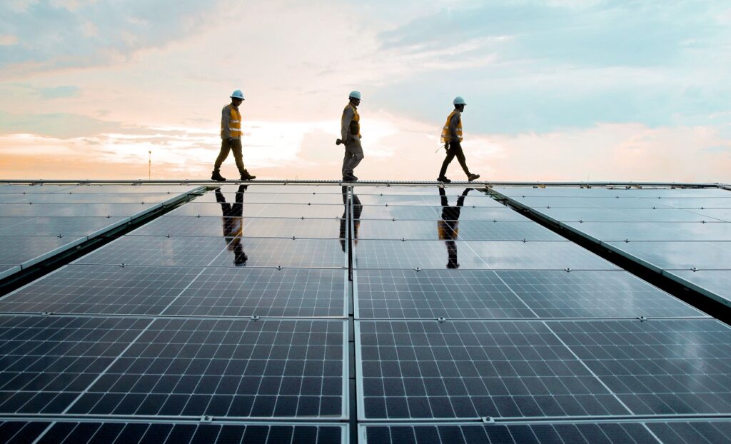 Three men walking across a solar panel array, harnessing renewable energy for a sustainable future